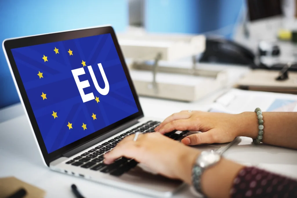 Person working on laptop with EU symbol, representing EU regulatory requirements and market access support